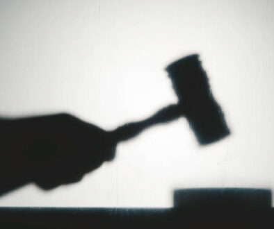 Silhouette view of hand with gavel. Representing justice system.